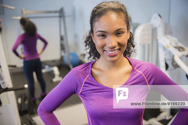 Mixed race woman smiling in gym