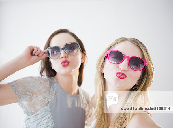 Women wearing colorful sunglasses and lipstick