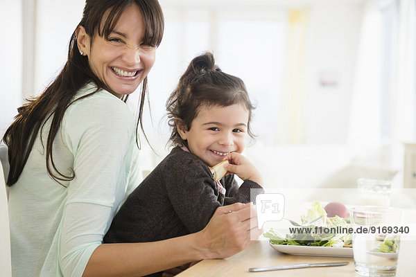 Hispanic mother and daughter eating together