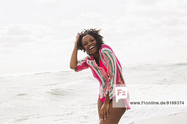 African American woman laughing on beach