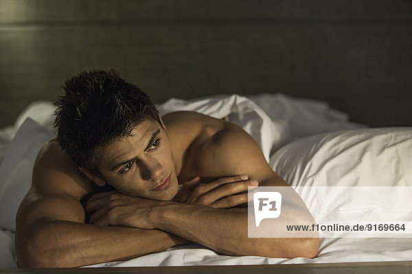 Caucasian man relaxing in bed