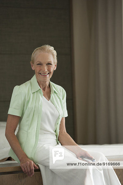 Senior Caucasian woman sitting on bed