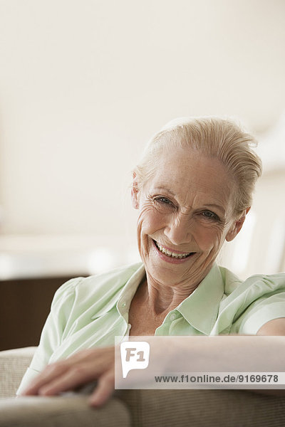 Senior Caucasian woman smiling on sofa
