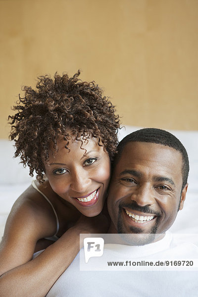 African American couple relaxing on bed