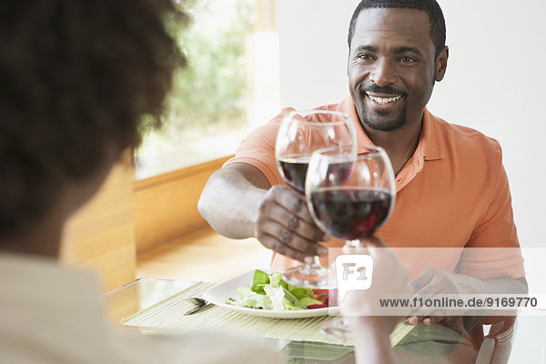 African American couple toasting each other at dinner