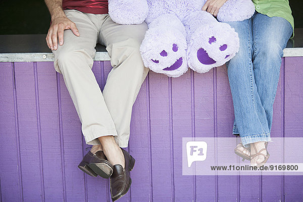 Caucasian couple with teddy bear at theme park