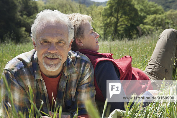 Senior Caucasian couple relaxing in tall grass
