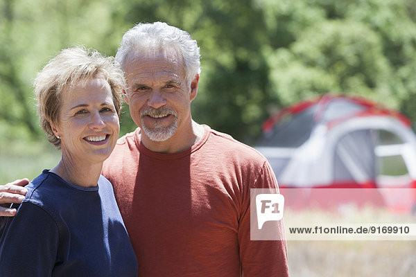 Senior Caucasian couple smiling at campsite