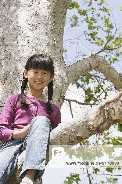 Chinese girl smiling in tree