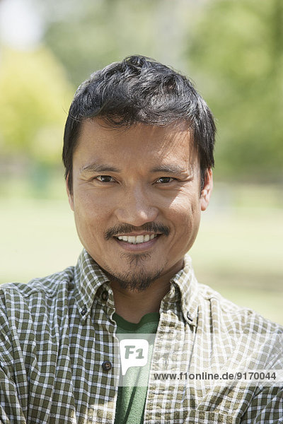 Asian man smiling outdoors