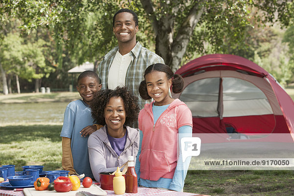 Family smiling together at campsite
