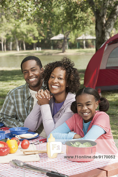 Family smiling together at campsite