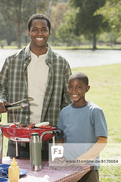 Father and son cooking at picnic table