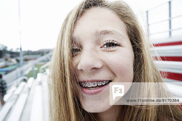 Teenage girl smiling on bleachers