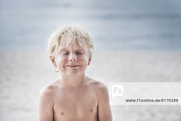 Caucasian boy smiling on beach