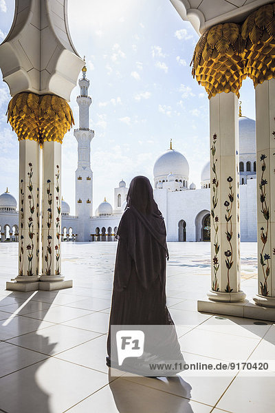 Woman walking at Sheikh Zayed Grand Mosque Abu Dhabi United Arab Emirates