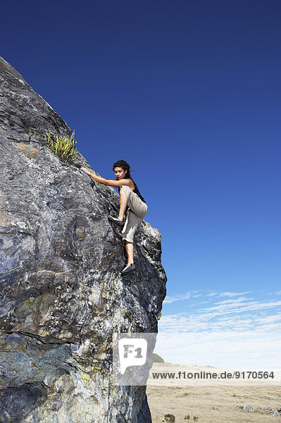 Hispanic climber scaling steep rock face