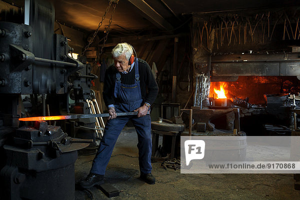 Germany  Bavaria  Josefsthal  senior blacksmith at work in historic blacksmith's shop