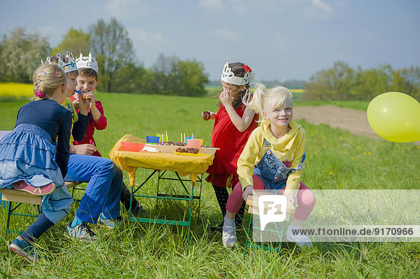Fünf Kinder mit Papierkronen zum Geburtstag