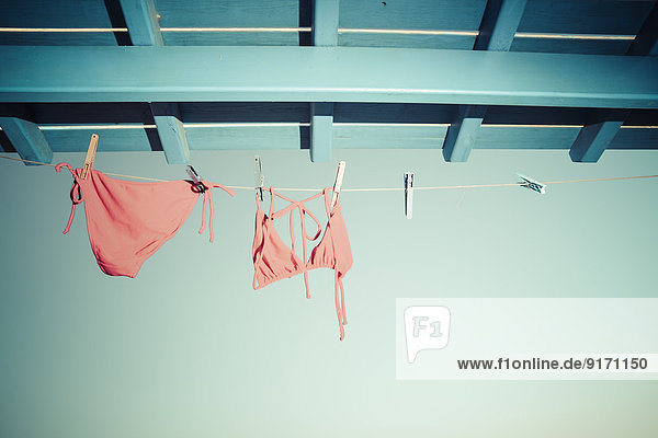 Bikini hängt an der Wäscheleine unter dem Dach