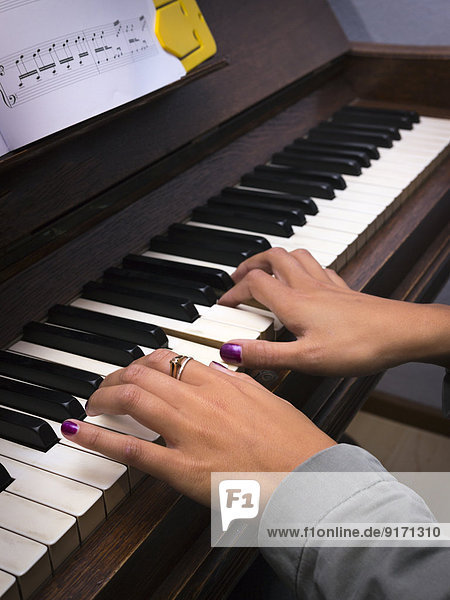 Young woman playing piano  partial view
