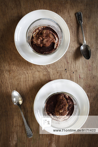 Zwei Gläser zuckerfreies Rhabarberquark-Dessert mit geriebenem Schwarzbrot,  erhöhte Ansicht