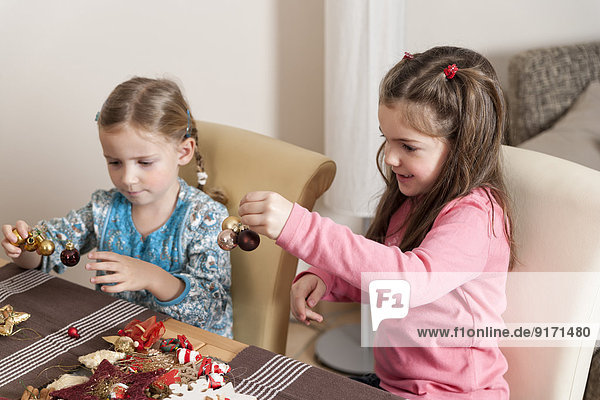 Two little girls tinkering Christmas decoration