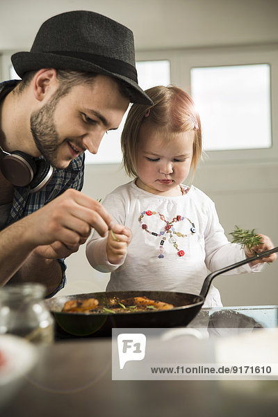 Father and daughter cooking in kitchen