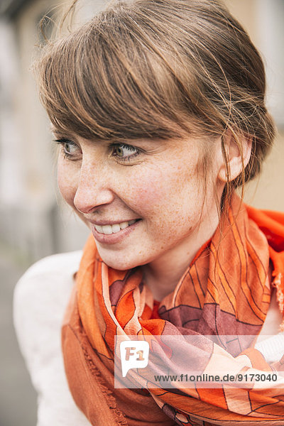Porträt einer lächelnden Frau mit orangem Schal