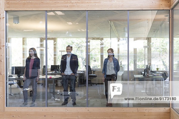 Team von drei Geschäftsleuten am Arbeitsplatz im modernen Büro