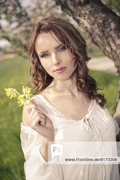 Porträt einer jungen Frau mit gelben Blumen