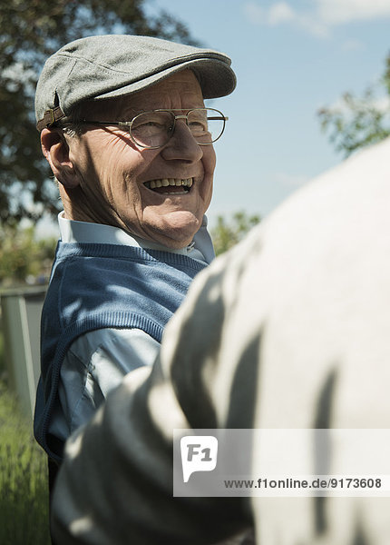 Portrait of happy old man wearing cap