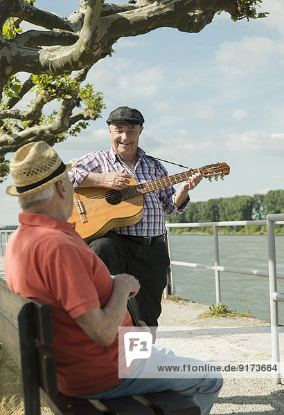 Germany  Rhineland-Palatinate  Worms  two old men with guitar at promenade of Rhine River