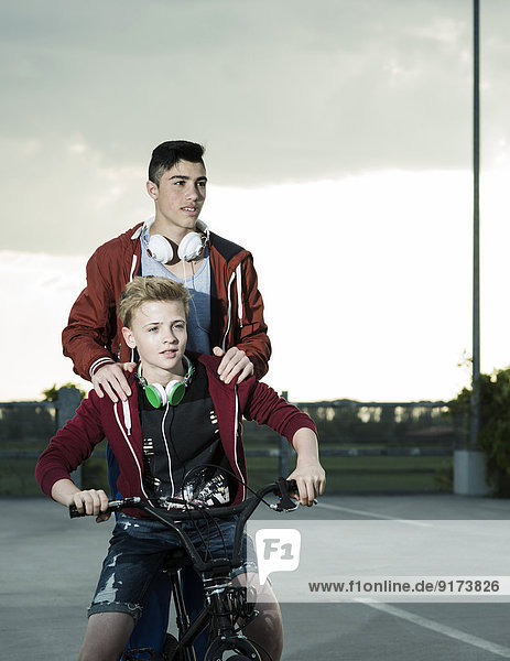 Two boys with BMX bike and headphones