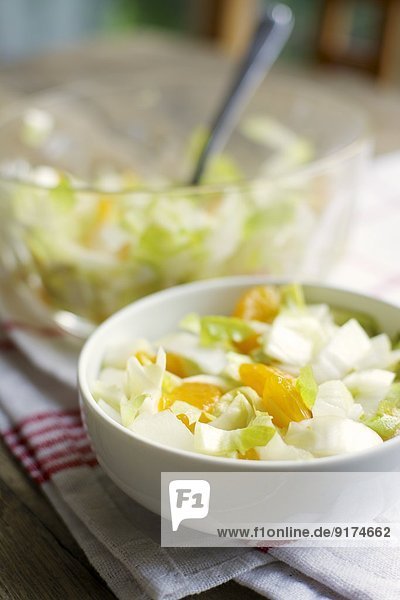 Bowls of Belgian endive salad with mandarin oranges on kitchen towel