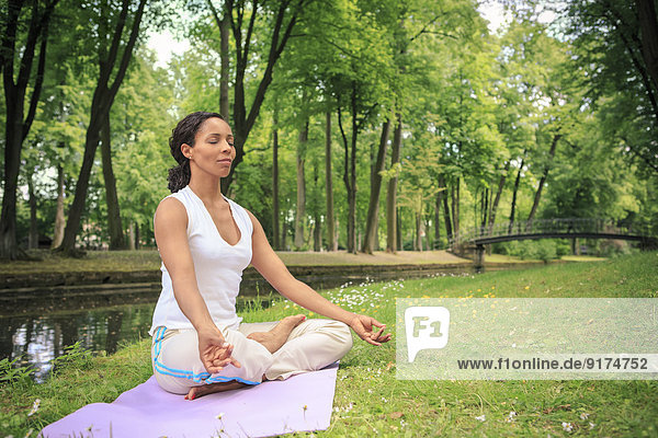 Germany  Woman exercising yoga in a park  Meditation