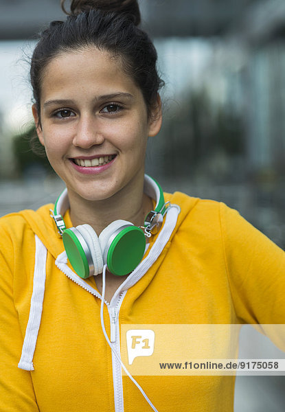 Porträt einer lächelnden jungen Frau im gelben Trainingsanzug