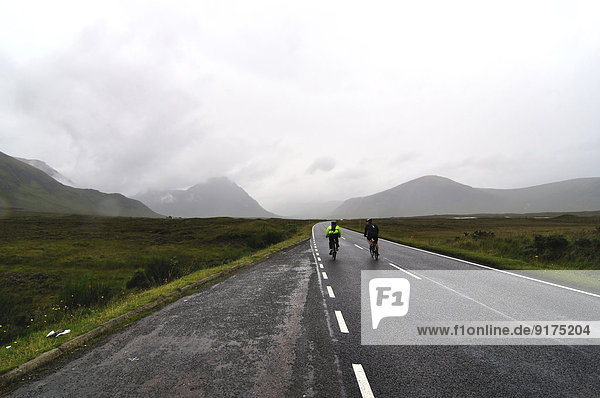 United Kingdom  Scotland  Cyclists in the rain in the Highlands