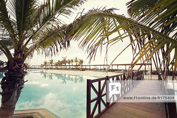 Spanien  Kanarische Inseln  La Palma  Fuencaliente  Schwimmbad mit Holzsteg und Palmen eines Hotels