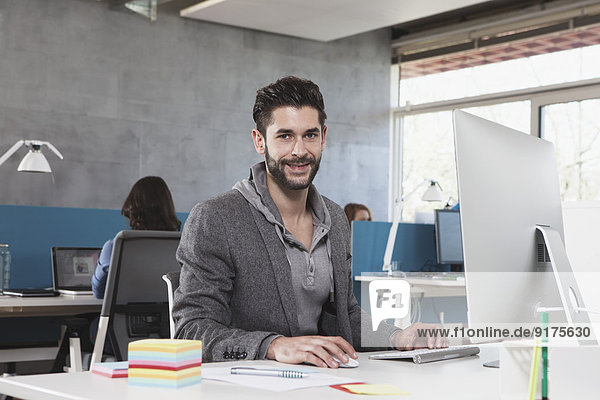 Portrait of smiling man at his workplace in the office