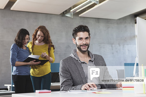 Portrait of smiling man at his workplace in the office
