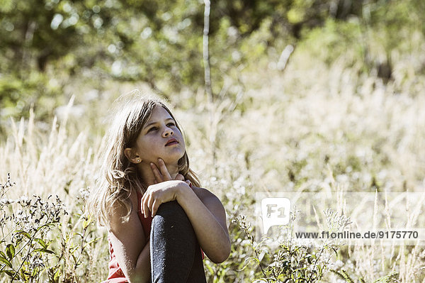 Girl sitting in meadow