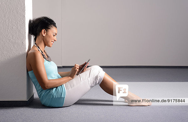 Junge Frau mit digitalem Tablett im leeren Raum