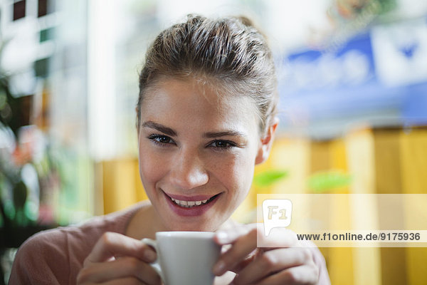 Frankreich  Paris  Porträt einer jungen Frau  die in einem Café eine Tasse Kaffee trinkt.
