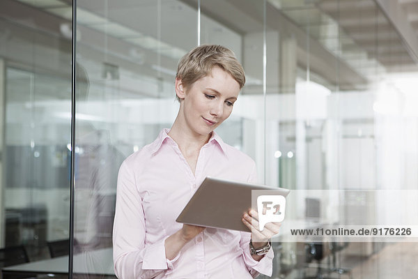 Germany  Munich  Businesswoman in office  using digital tablet