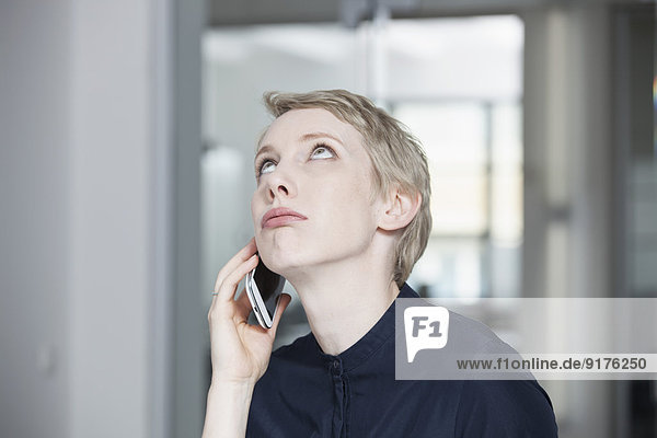 Germany  Munich  Businesswoman in office  using smart phone