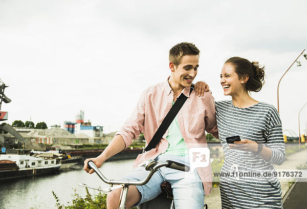 Young couple with bicycle and smartphone