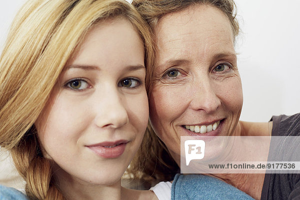 Portrait of mother and daughter head to head