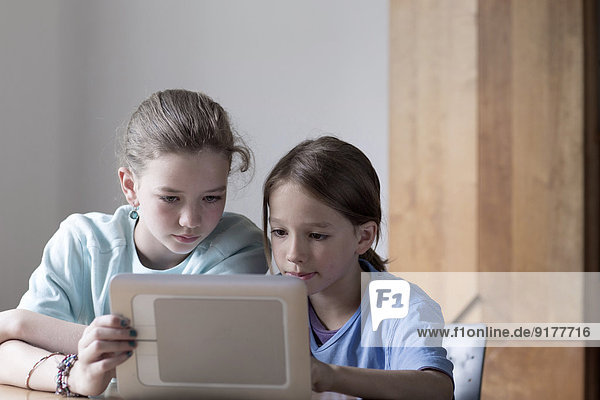Bruder und Schwester beim Betrachten des Tablet-Computers zu Hause