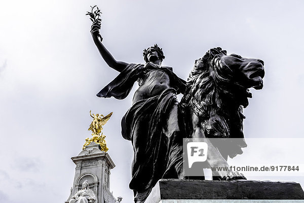United Kingdom,  England,  London,  Westminster,  Victoria Monument,  Statues of Queen Victoria and Goddess of Victory and Statue of a woman with lion in the foreground